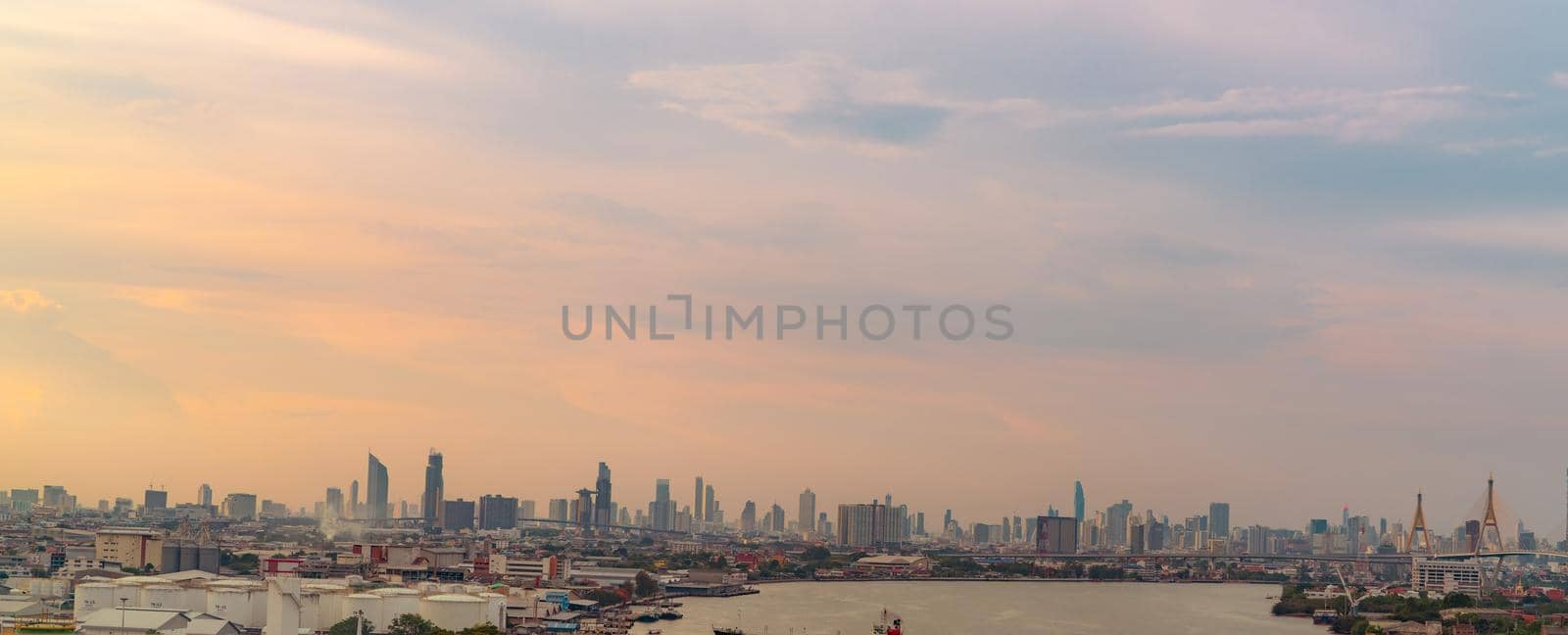Cityscape of modern building. Cityscape in Asia. Business office building. City with sunset sky. Horizontal view of city with crowd of skyscraper building and the river. Capital city in Thailand. by Fahroni