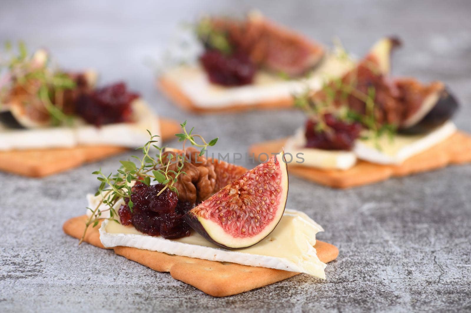 Cracker with a slice of camembert with confiture and figs by Apolonia