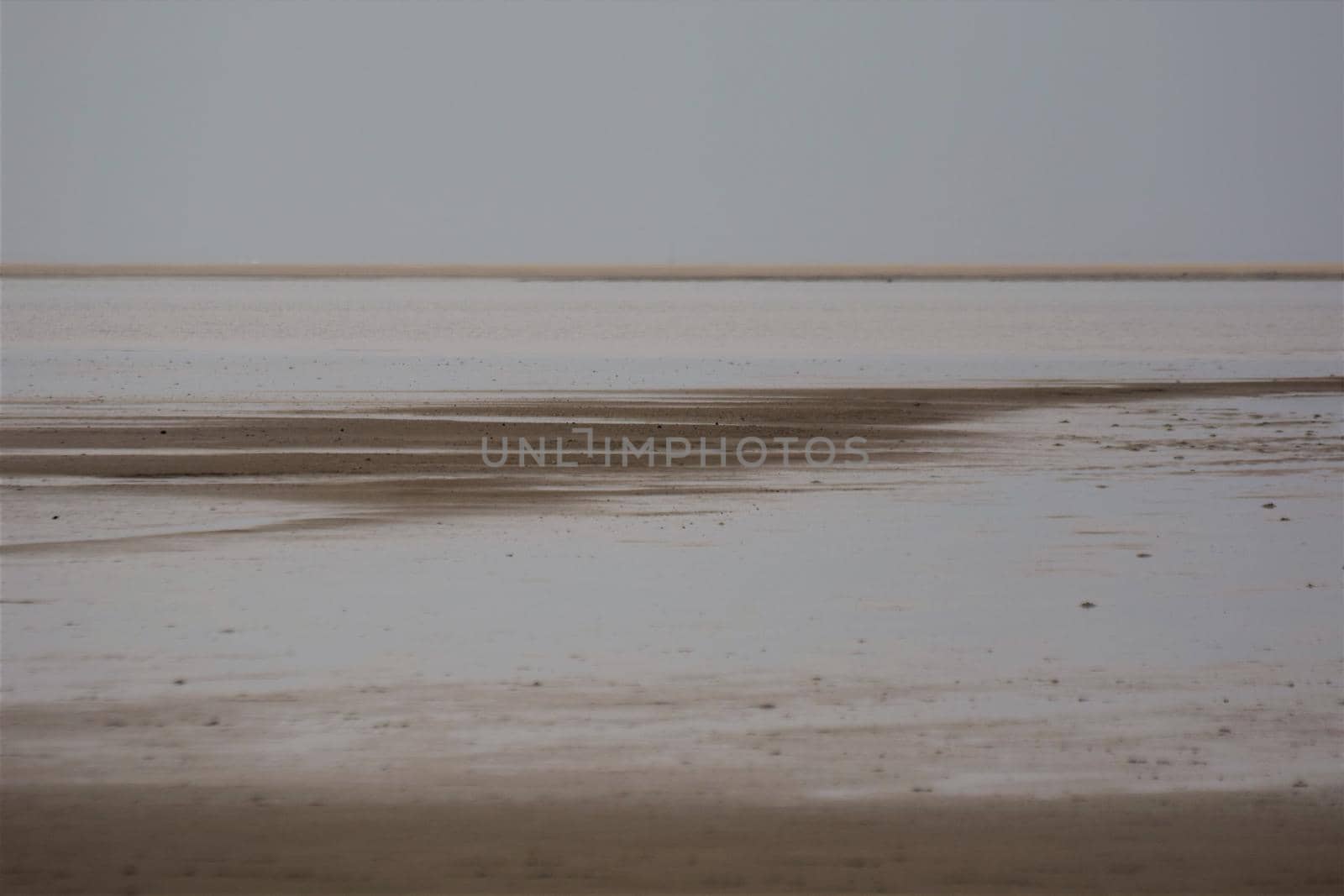 Beach of an island at low tide with a sandbank in the background