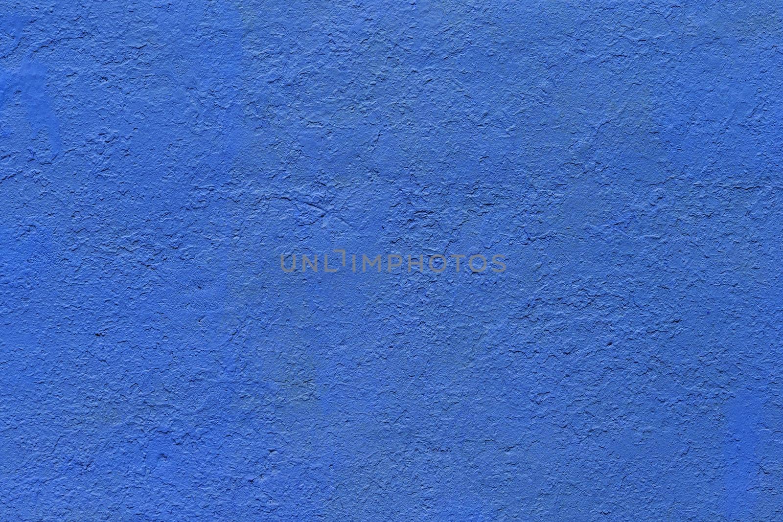 background and texture of flat thick painted matte blue surface under direct sunlight - new paint over fragments of old peeled one
