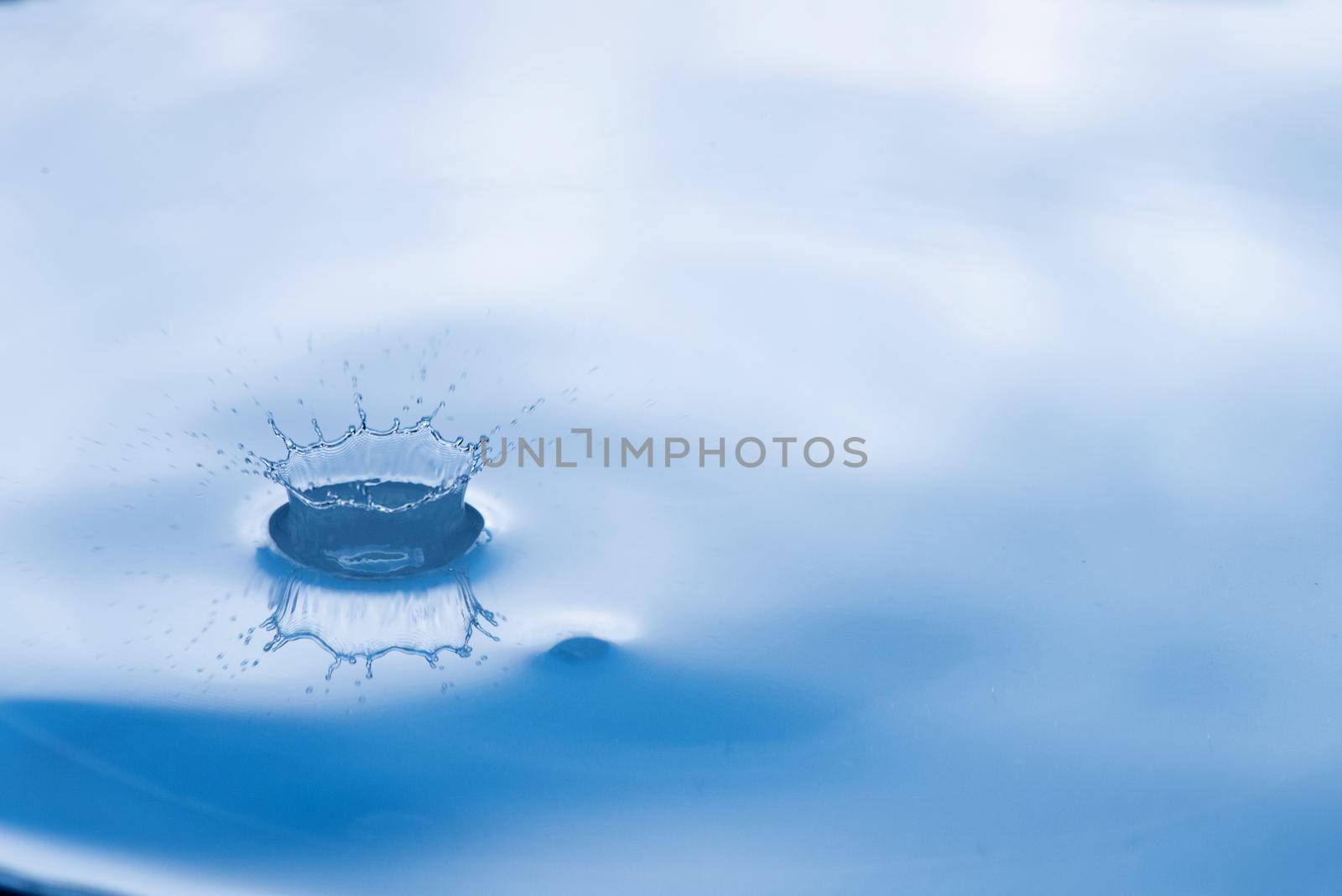 Water drop splash with reflection.