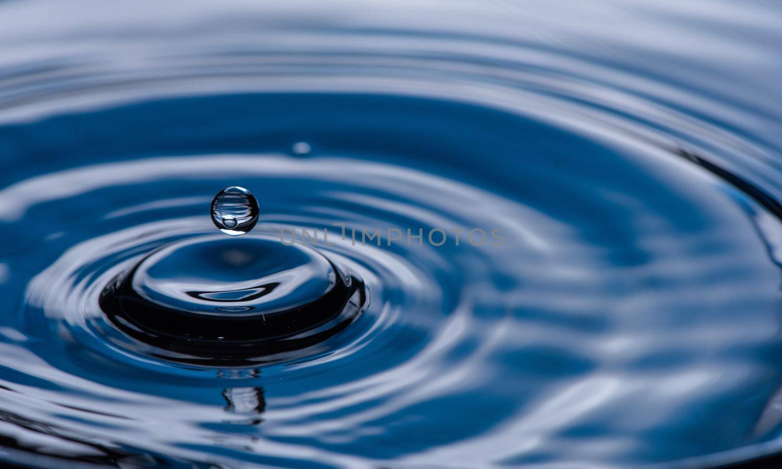 Water drop splash on blue colored.