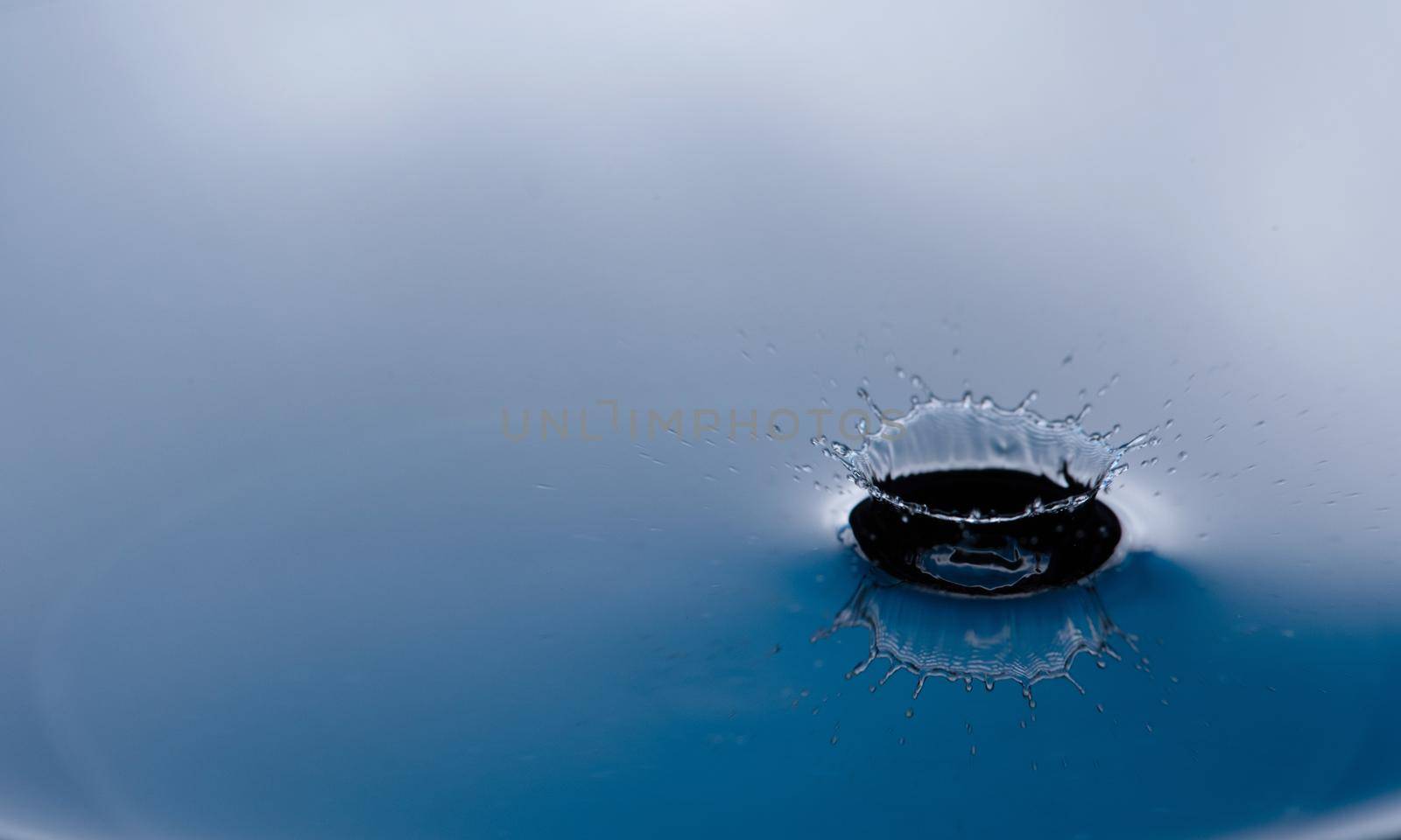 Water drop splash with reflection.