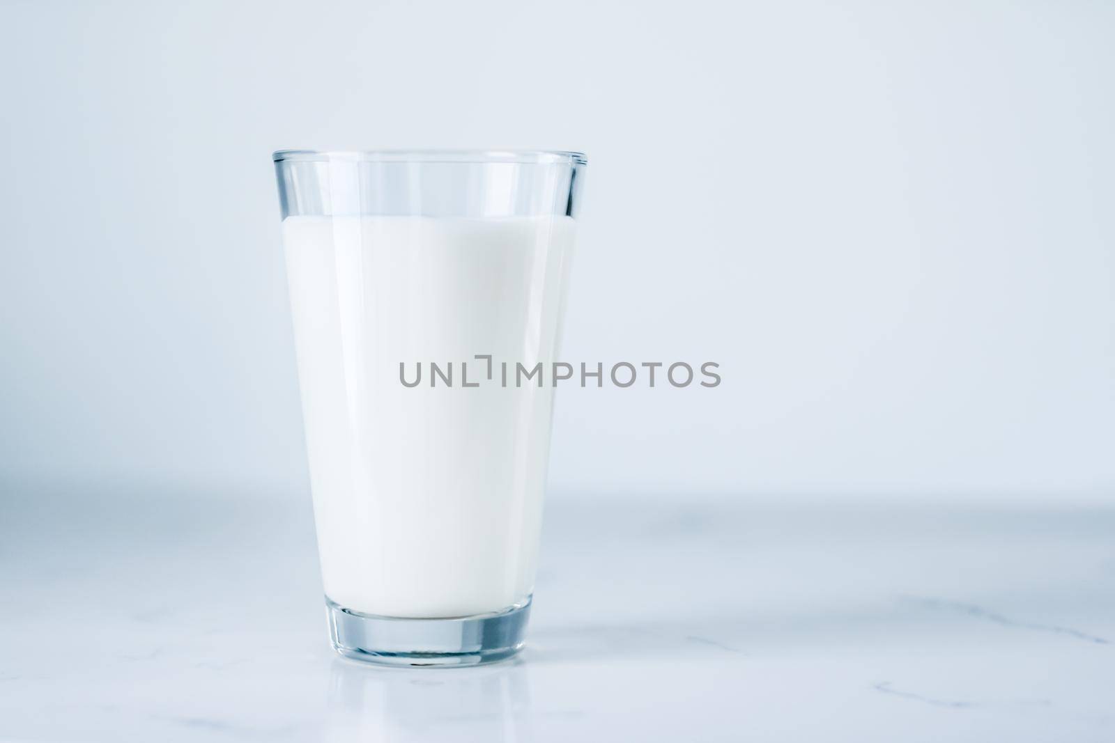 Dairy, healthy nutrition and breakfast concept - World Milk Day, full glass on marble table