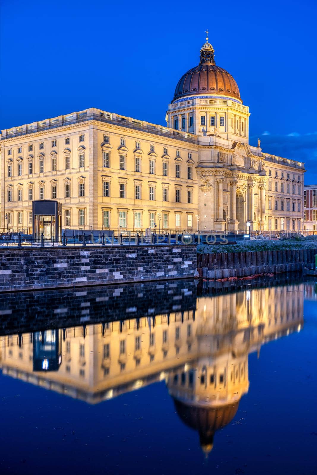 The reconstructed Berlin City Palace at night reflected in the river Spree