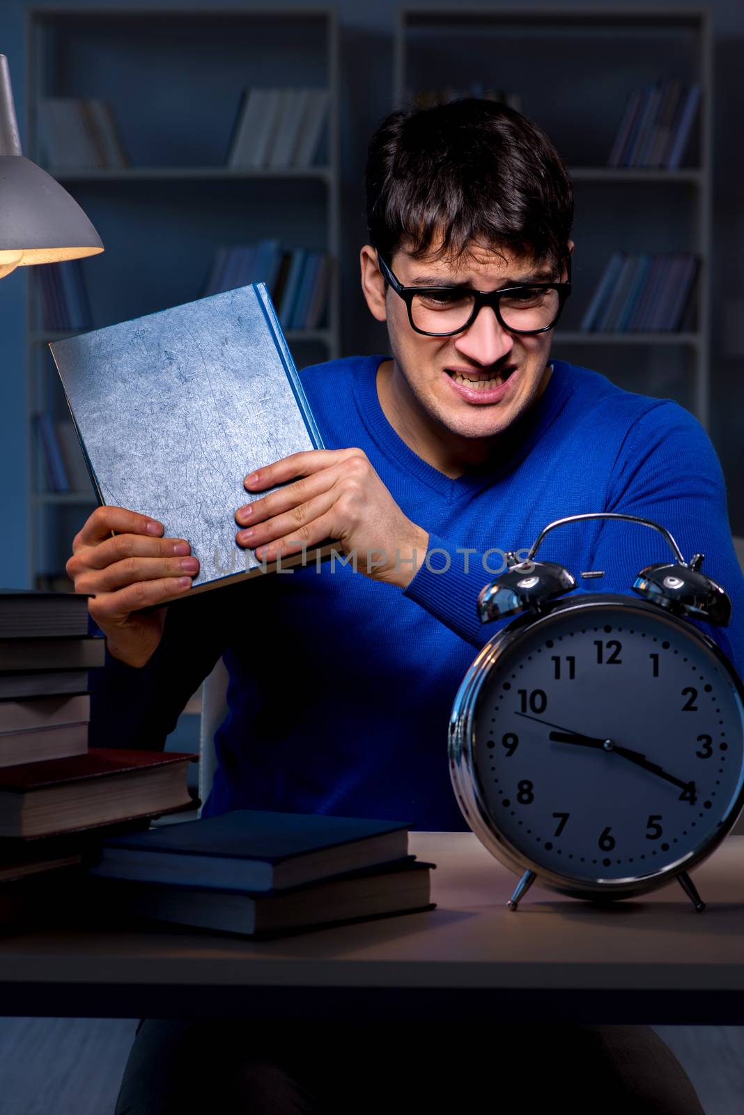 Student preparing for exams late at night in library
