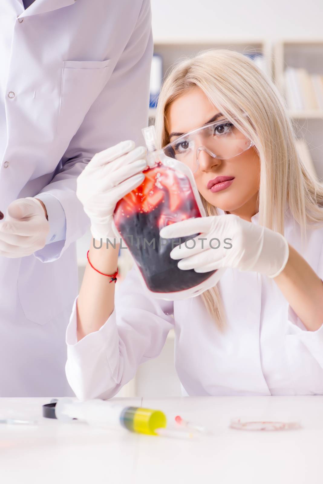 Woman female doctor looking at blood samples in bag