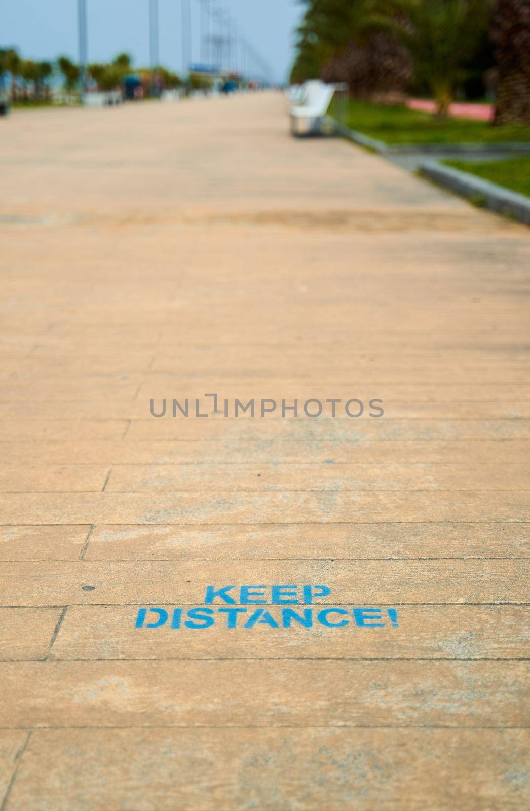 the inscription on the floor is a reminder of keeping the distance. Walking path on the embankment.