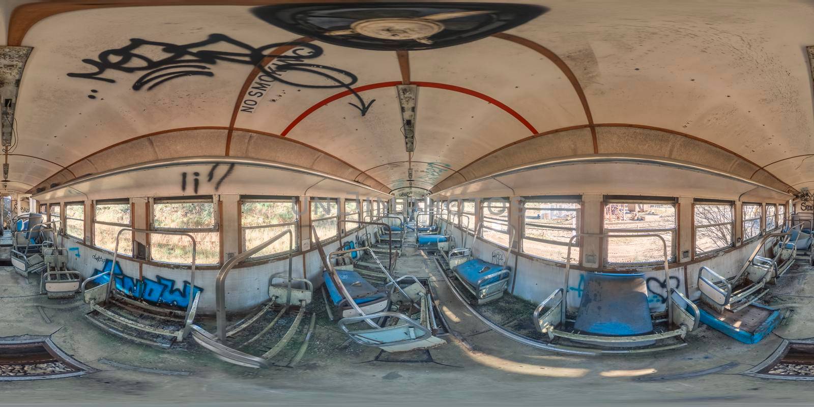 Spherical panoramic photograph of the inside of an old and vandalised train carriage