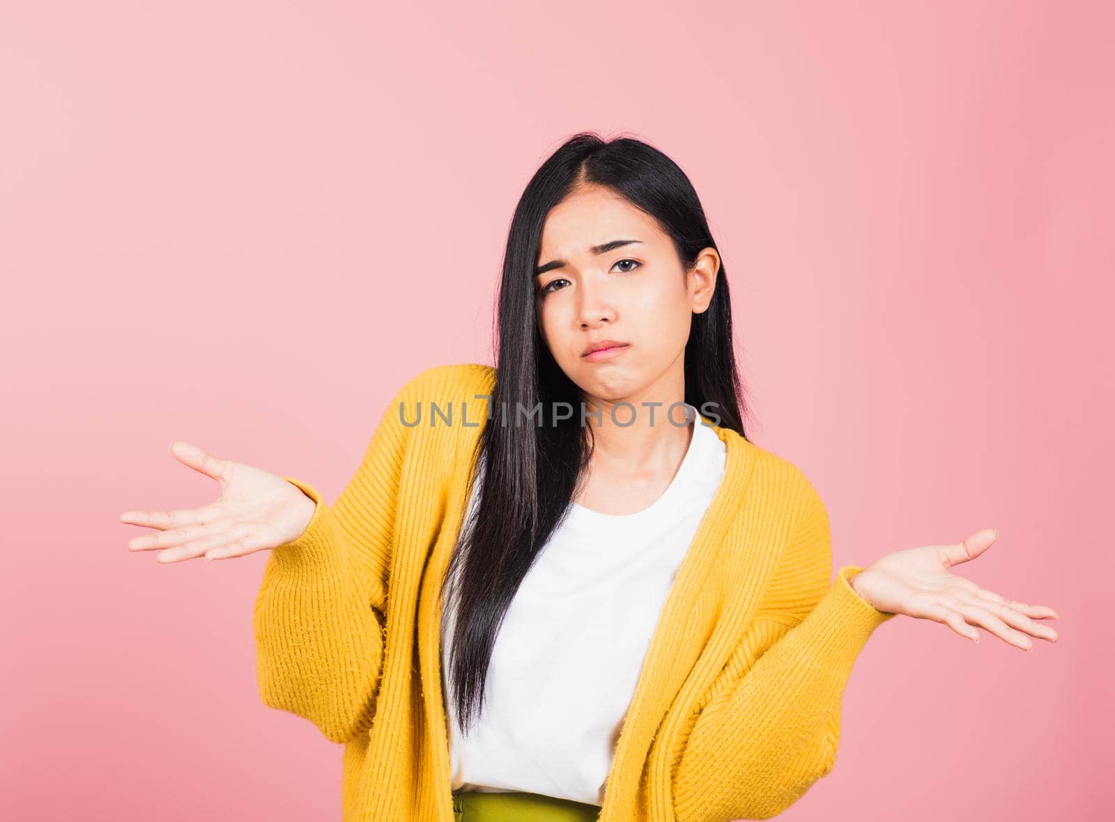 Asian portrait beautiful cute young woman teen shrugging with spread hands she shocked dont understand and confused studio shot isolated on pink background, female doubt with copy space
