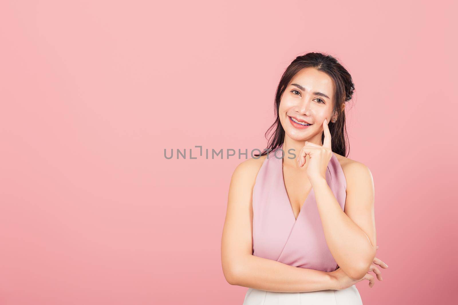 Portrait Asian beautiful young woman smiling standing chin handle relaxed thinking about something about the question studio shot isolated on pink background, Thai female idea think with copy space