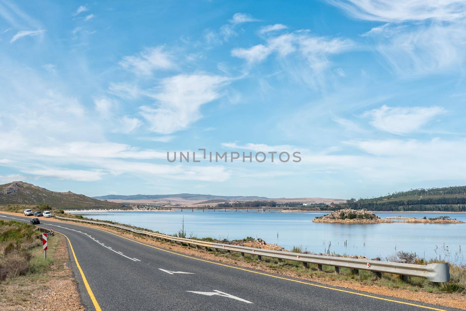The Theewaterskloof Dam in the Western Cape Province as seen from road R45. Vehicles and a road bridge are visible