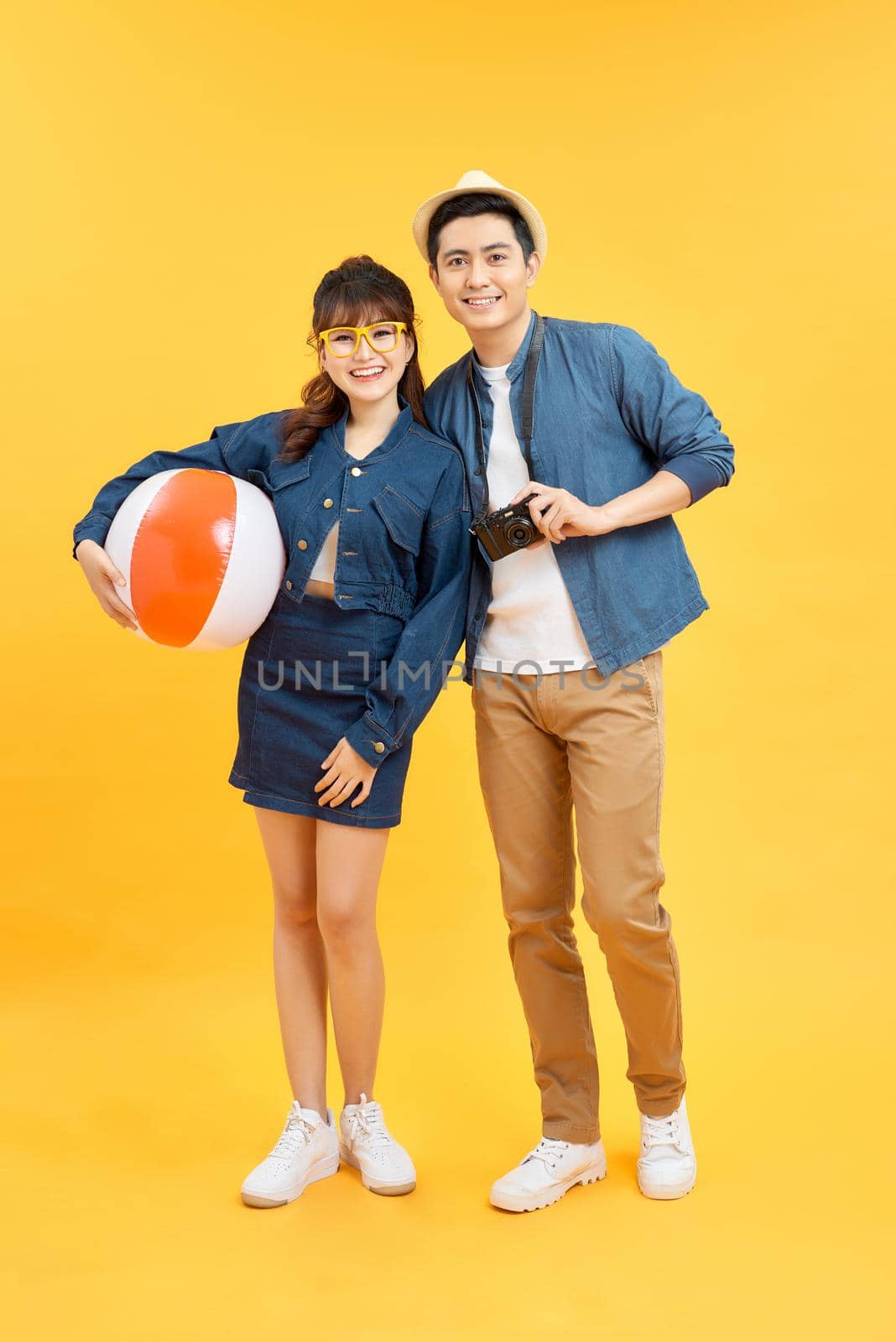 Lovely Asian couple in summer casual clothes and beach accessories studio shot isolated by makidotvn
