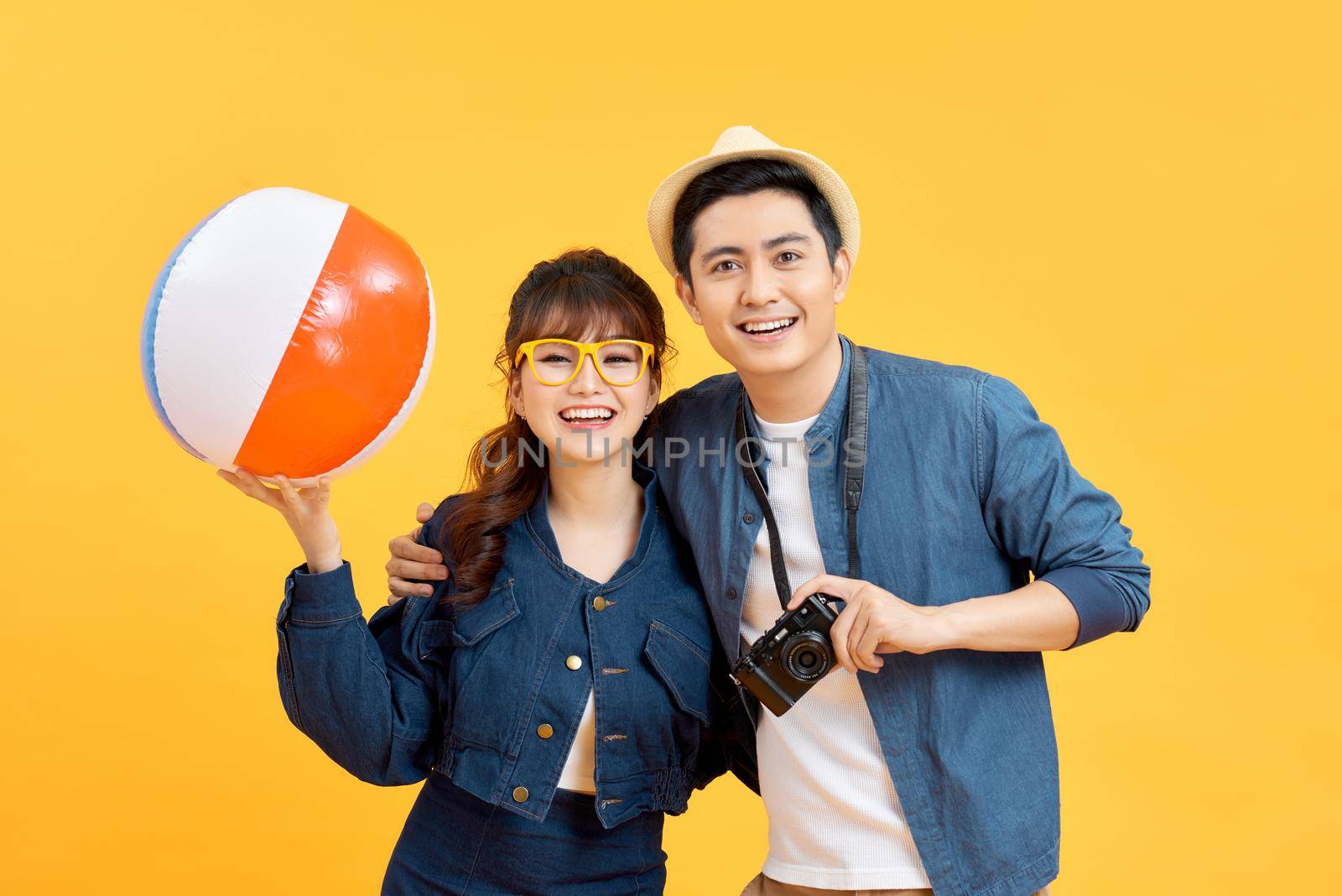 Happy Asian couple in summer beach casual clothes studio shot isolated on yellow banner background with copy space by makidotvn