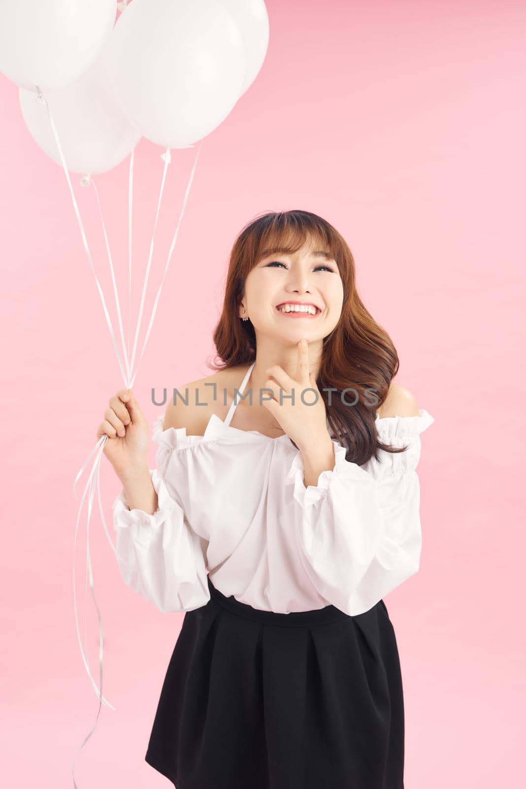 Portrait of smiling happy lady with air balloons on pink background. People concept