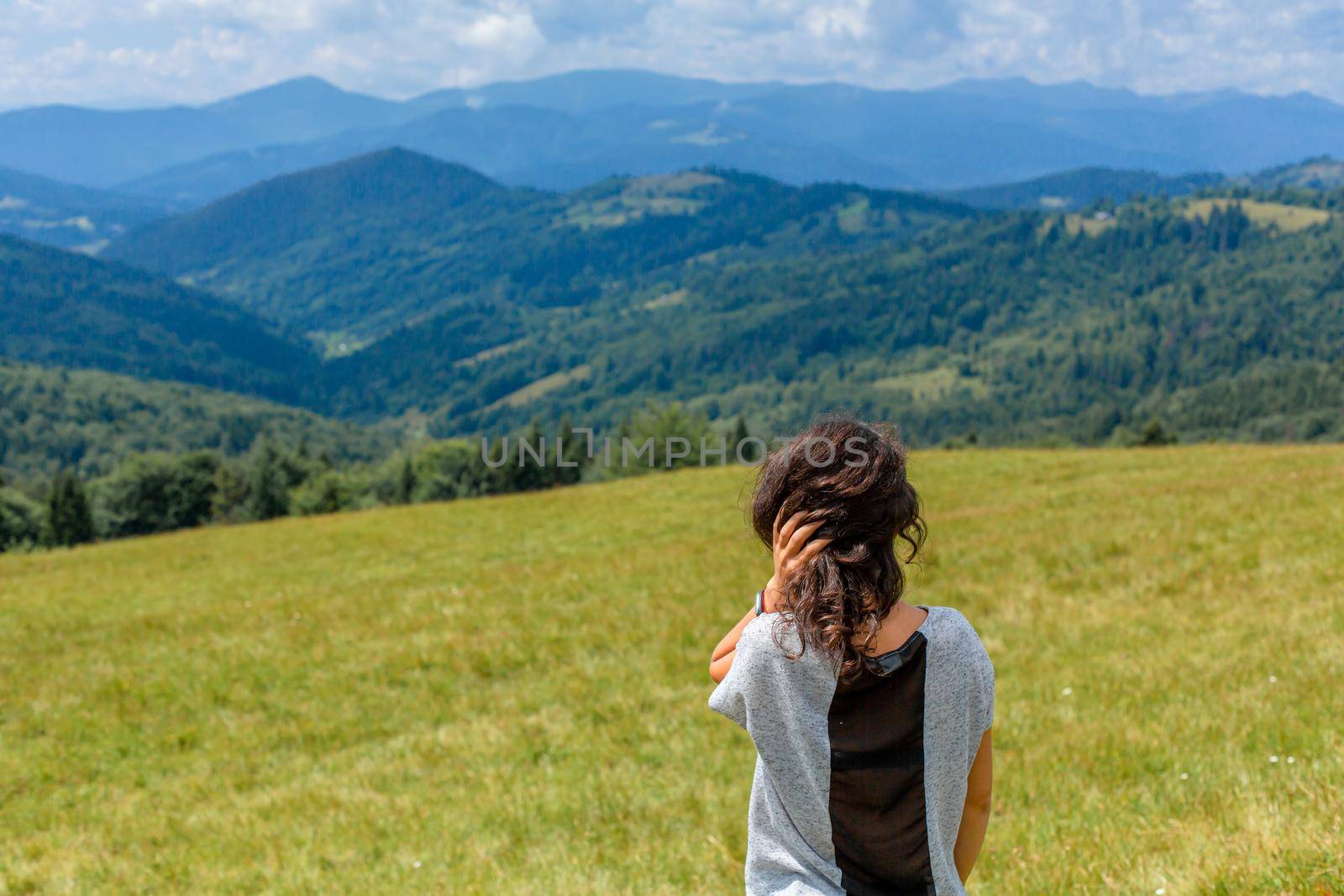Happy gorgeous girl enjoy mountain view stay on the hill with breathtaking mountain landscape.