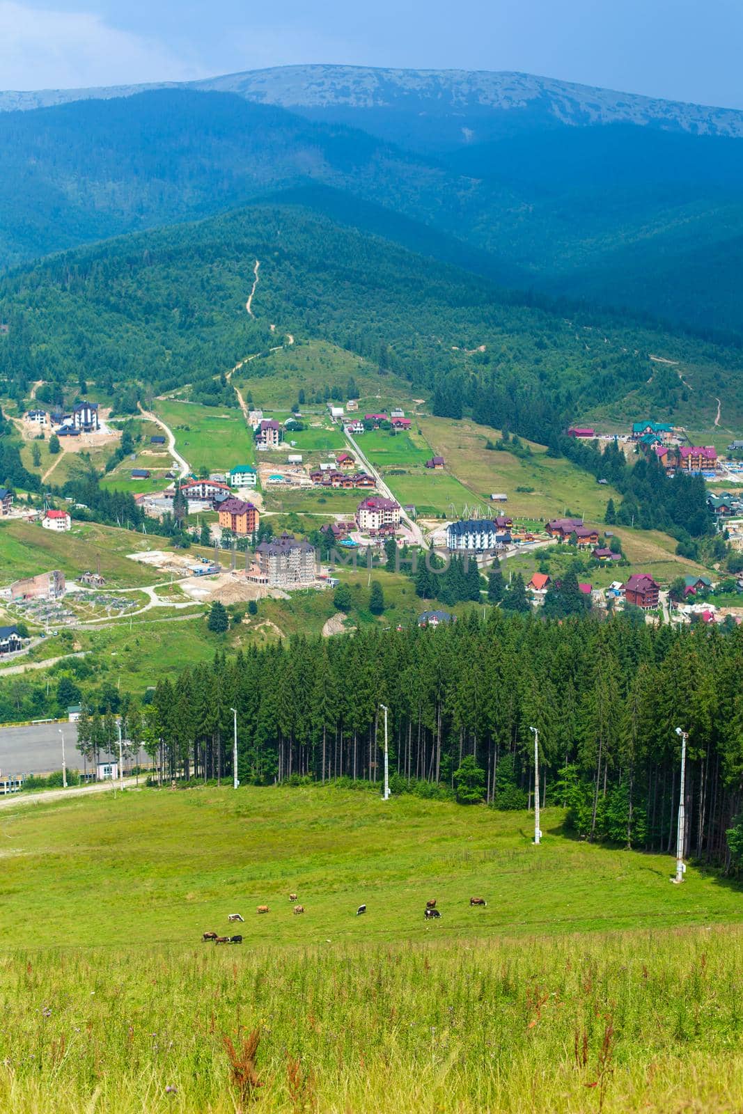 Mountain ski slope in summer day. Green mountains landscape on background.