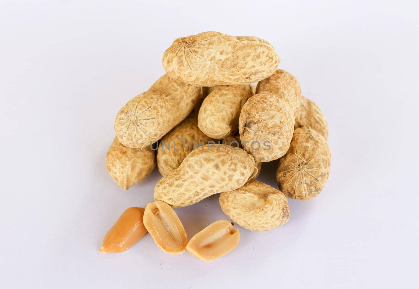 Peanuts stacked separately on white background . Separated seeds in front. by pichai25