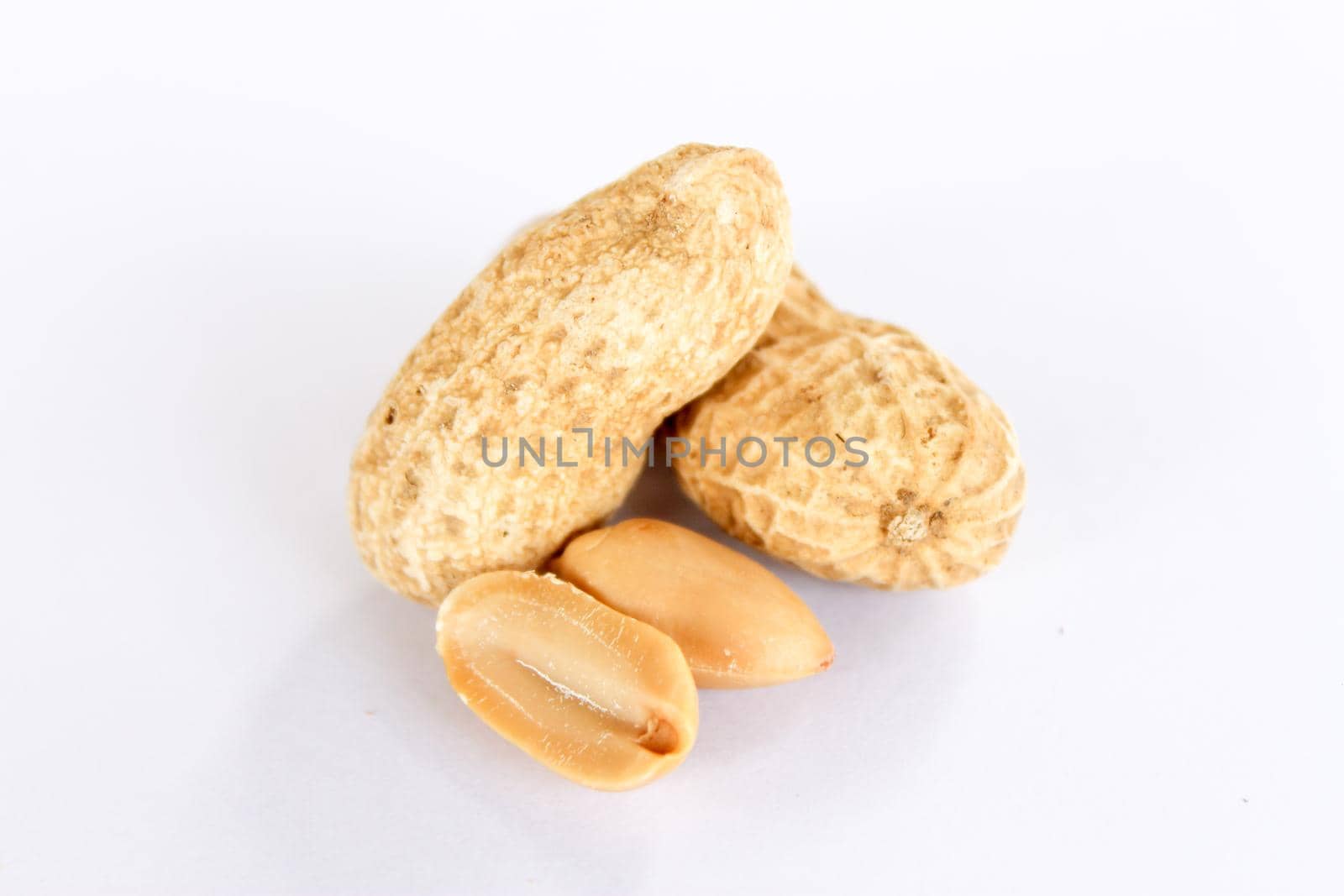 Peanuts are on a white background. There was a peanut seed that had been carved out in front. by pichai25