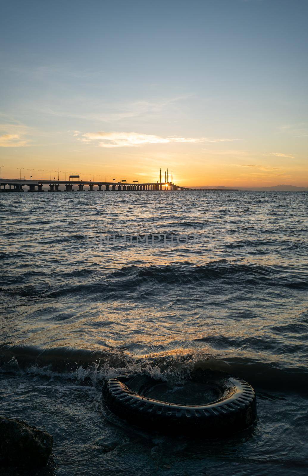 Old tire left at coastal. Background is Penang Bridge. Environmental pollution.