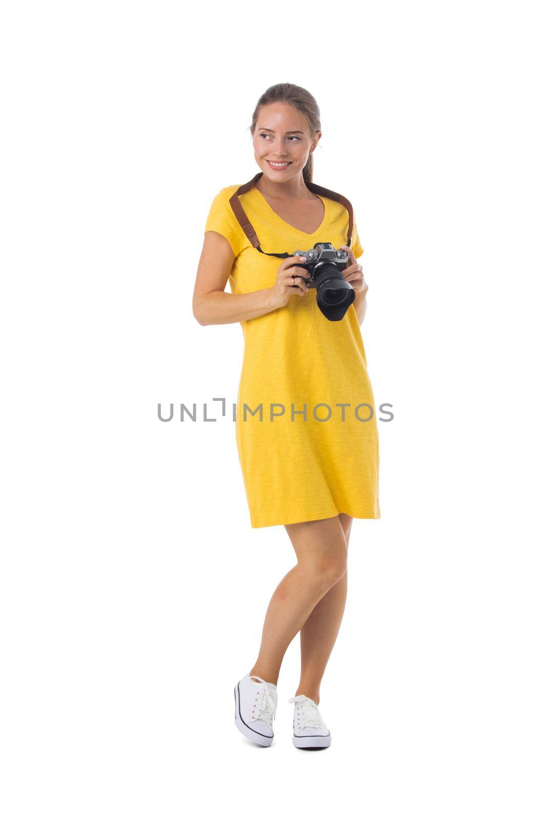 Young beautiful photographer girl in yellow dress with camera isolated on white background