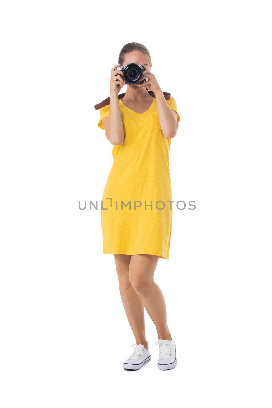 Young beautiful photographer girl in yellow dress with camera isolated on white background