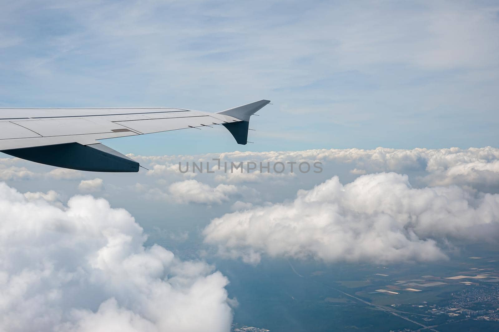 View from airborne airplane window at cloudy sky at high altitude.