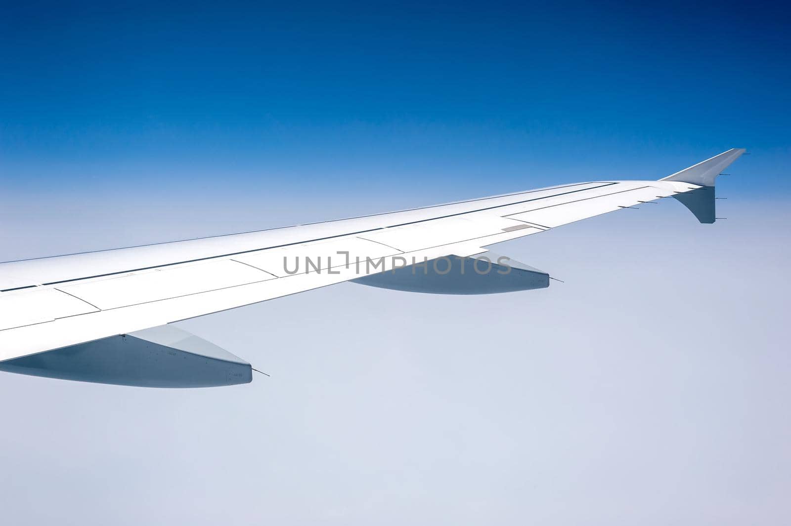 View from airborne airplane window at cloudy sky at high altitude.