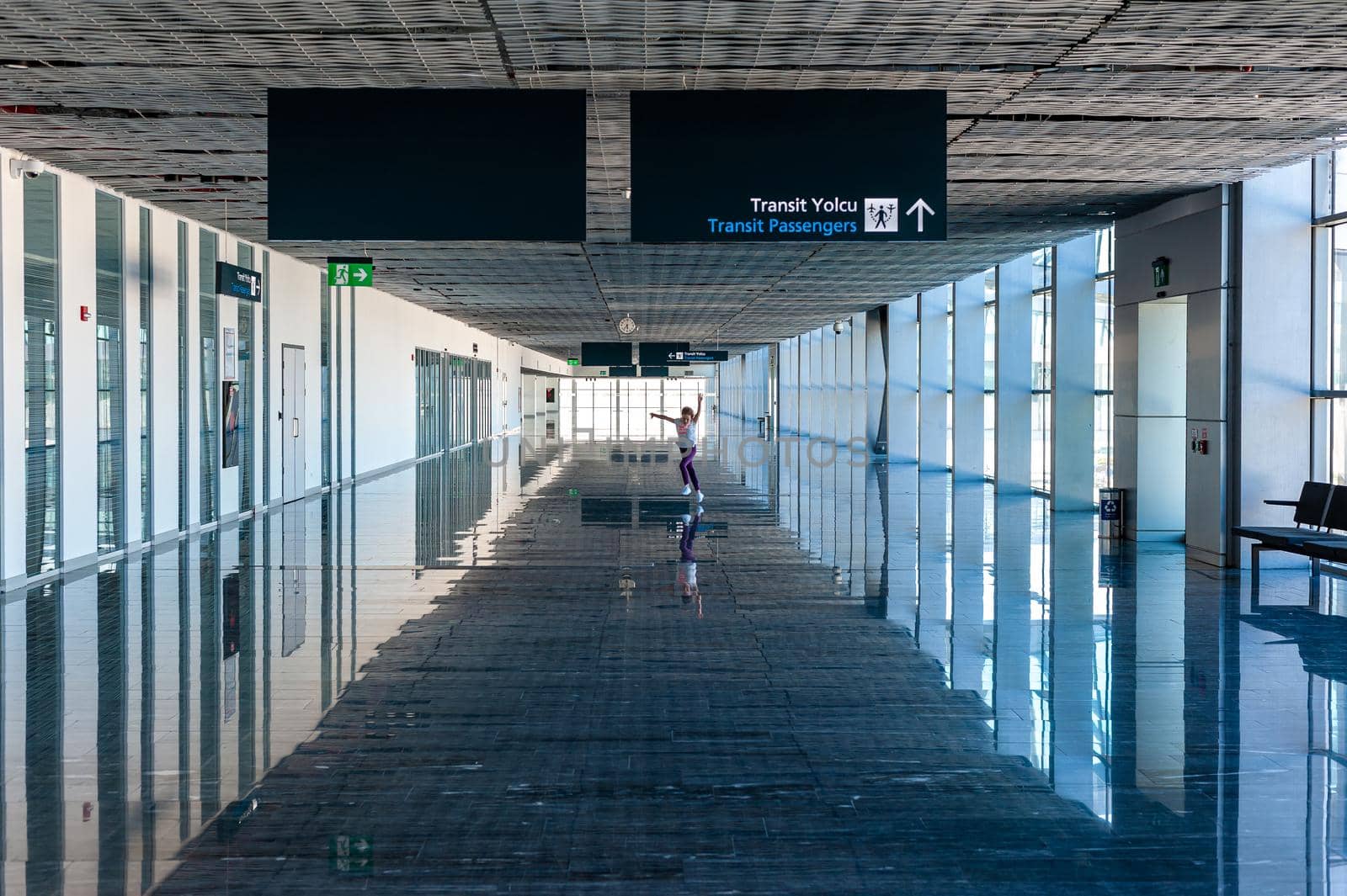 05/26/2019 Bodrum Airport / Milas Mugla Airport. Turkey. Small girl running along long corridor out of boredom while awaiting for her flight.