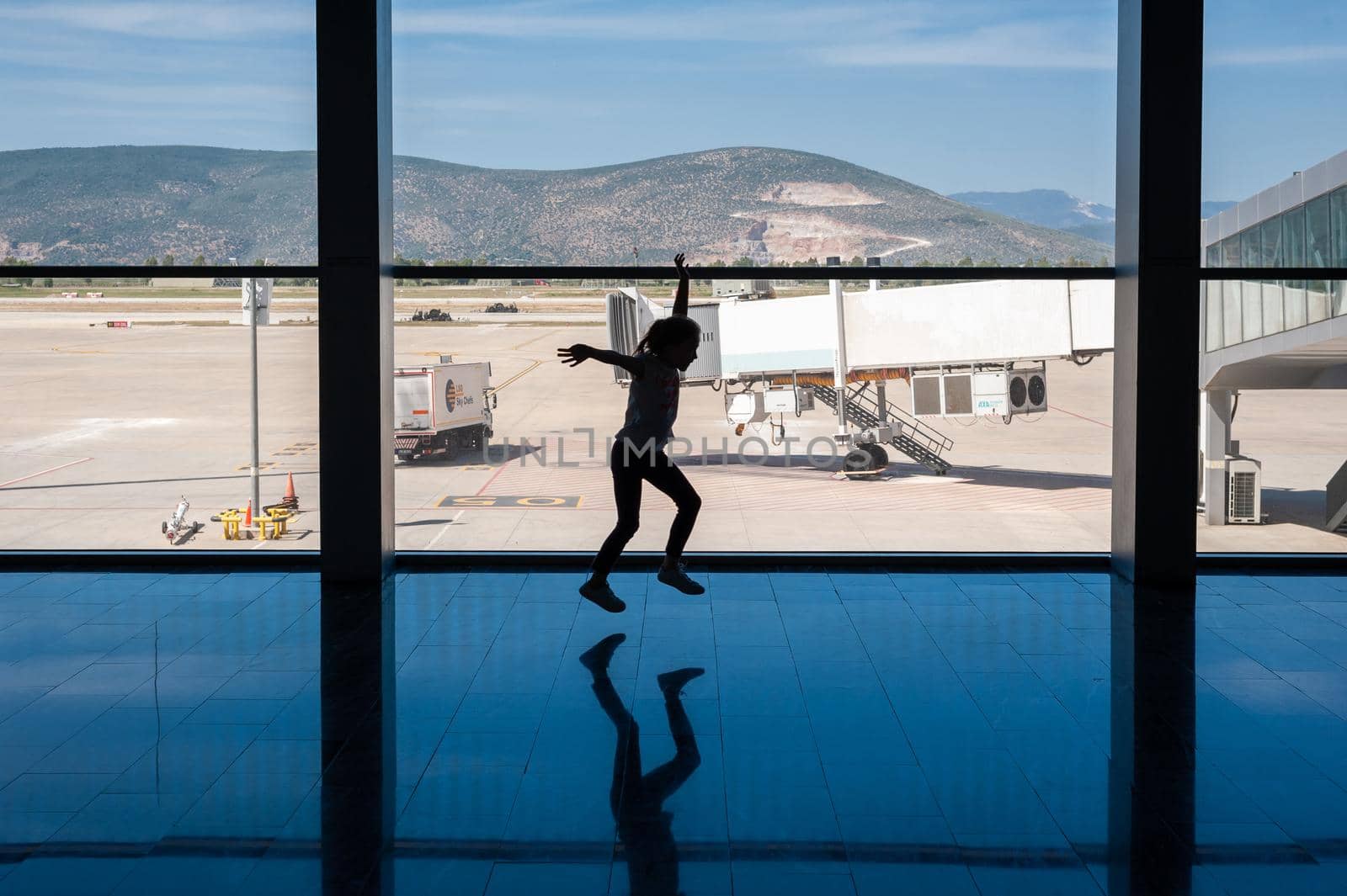 05/26/2019. Bodrum Airport / Milas Mugla Airport. Turkey. Small girl doing cartwheels exercise out of boredom while awaiting for her flight. by Qba