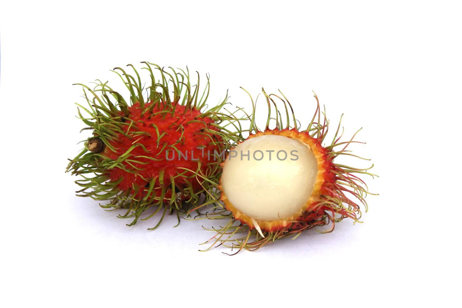 Sweet rambutans are peeled and placed separately on a white background, revealing the pulp of the fruit inside. by pichai25