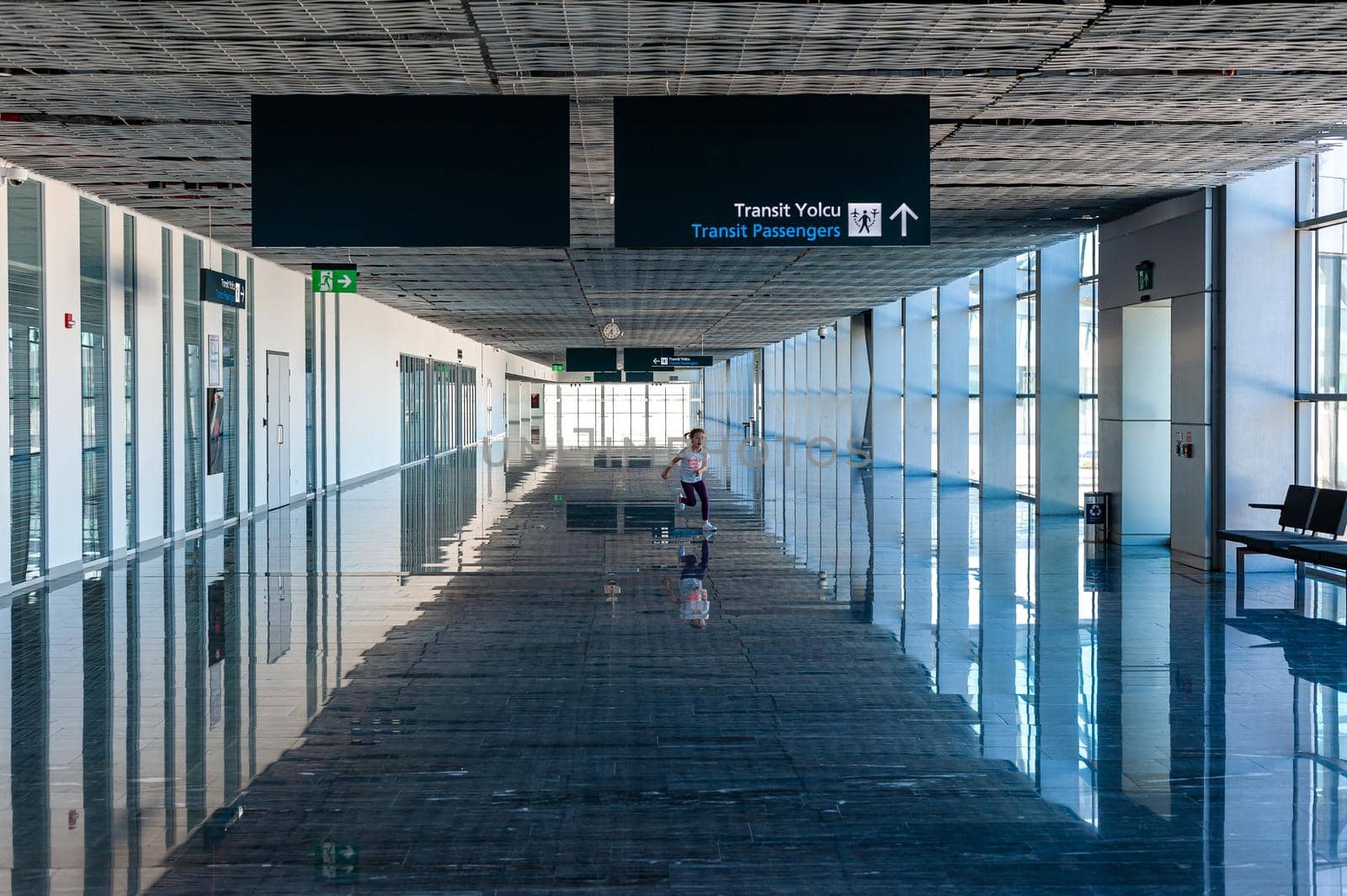 05/26/2019 Bodrum Airport / Milas Mugla Airport. Turkey. Small girl running along long corridor out of boredom while awaiting for her flight. by Qba
