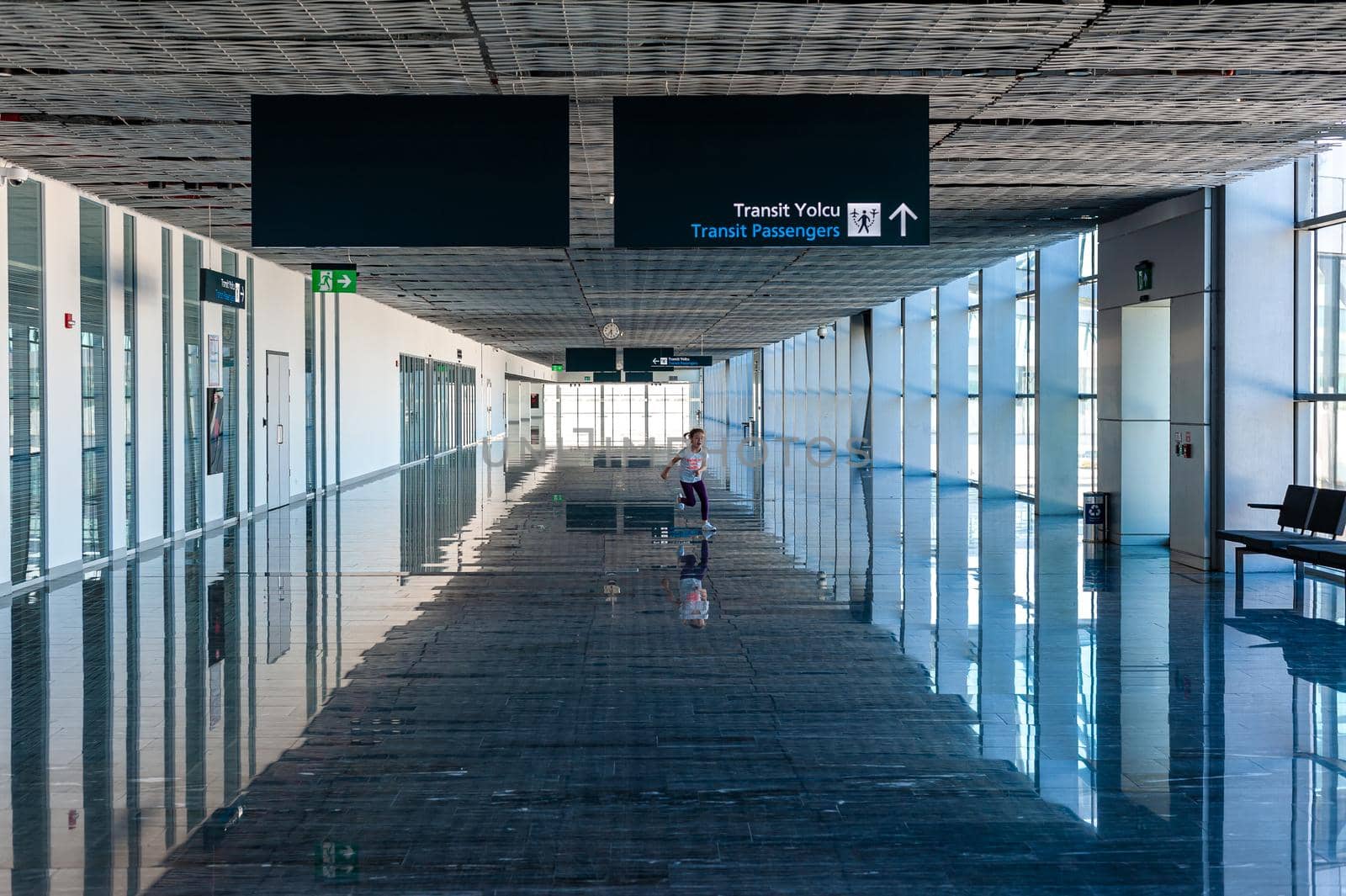 05/26/2019 Bodrum Airport / Milas Mugla Airport. Turkey. Small girl running along long corridor out of boredom while awaiting for her flight.