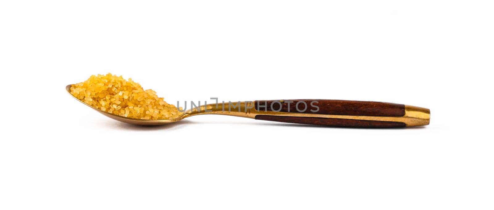 Close up one vintage golden metal spoon with wooden handle full of raw brown cane sugar, isolated on white background, low angle, side view