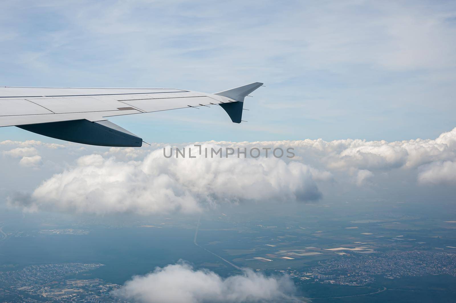 View from airborne airplane window at cloudy sky at high altitude.