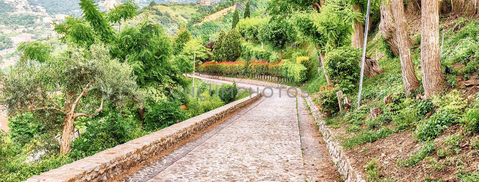 Stone paved road surrounded by nature on the hill near the city of Cosenza, Italy
