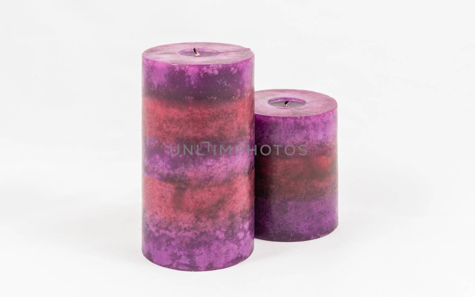 Group of scented purple candles, isolated on white background