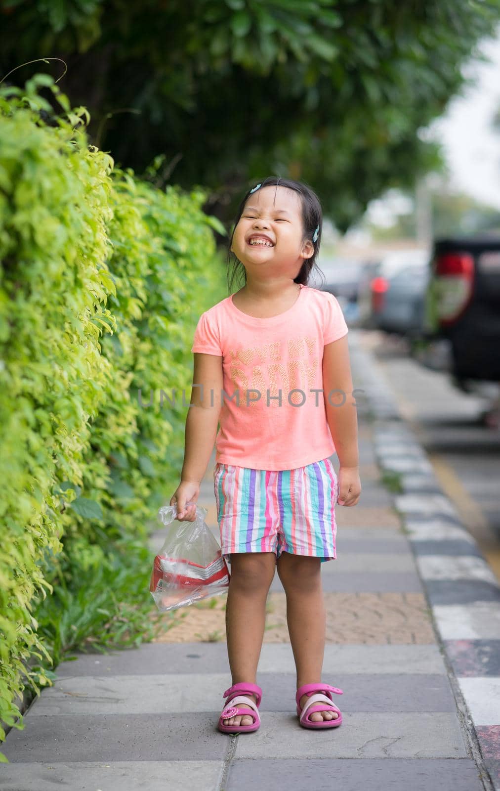 little girl walking on the footpath in car park by domonite