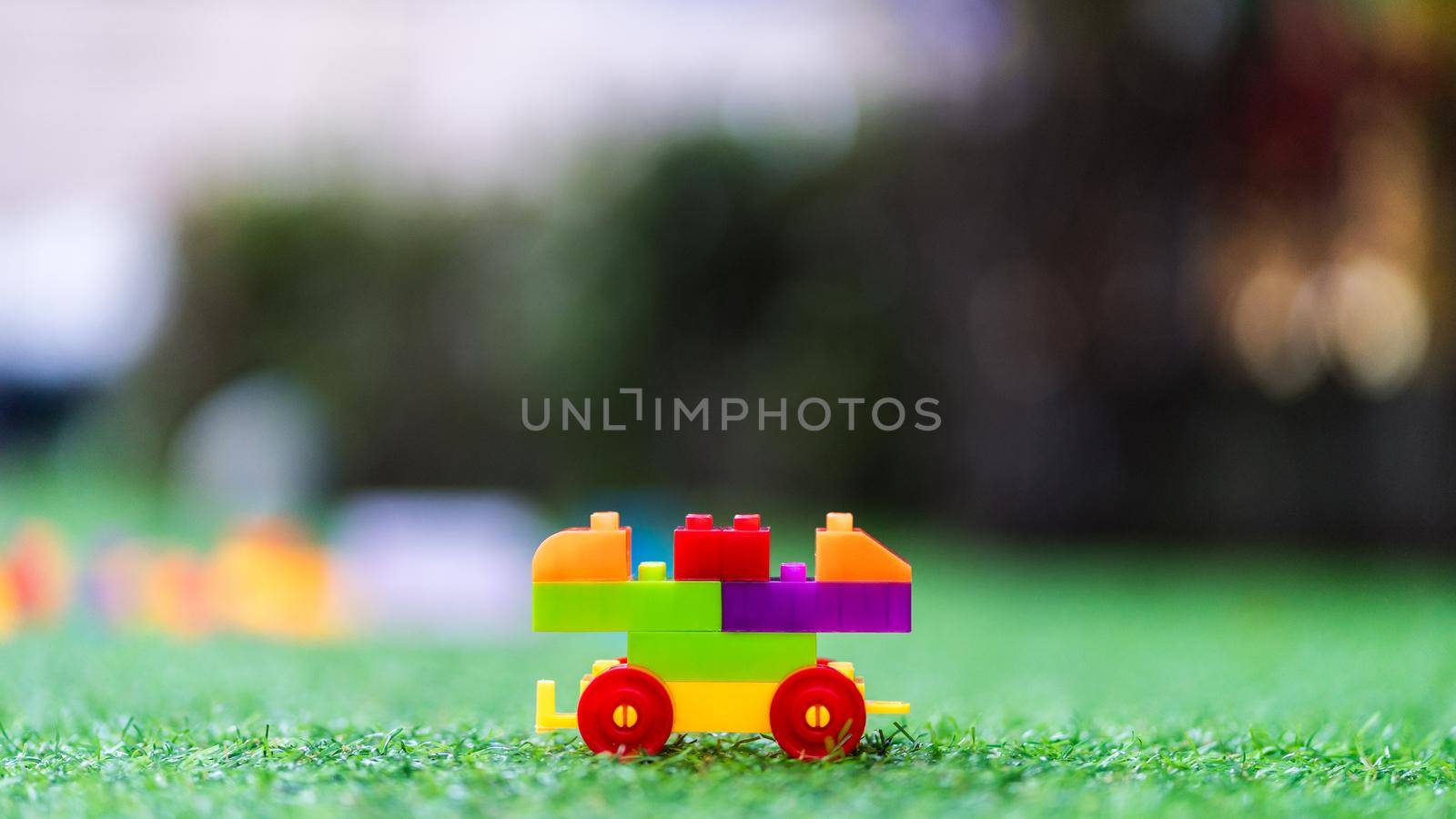 Toy colorful plastic blocks assembled to build a car on playground