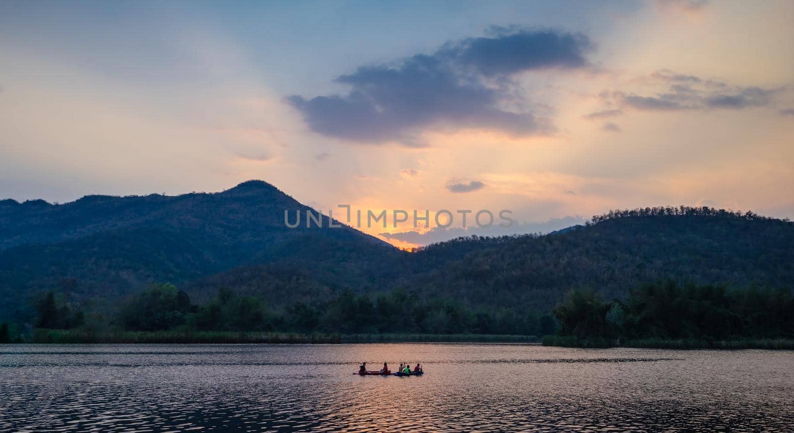Group of tourists on a kayak paddle in dam river with mountain landscape view by domonite