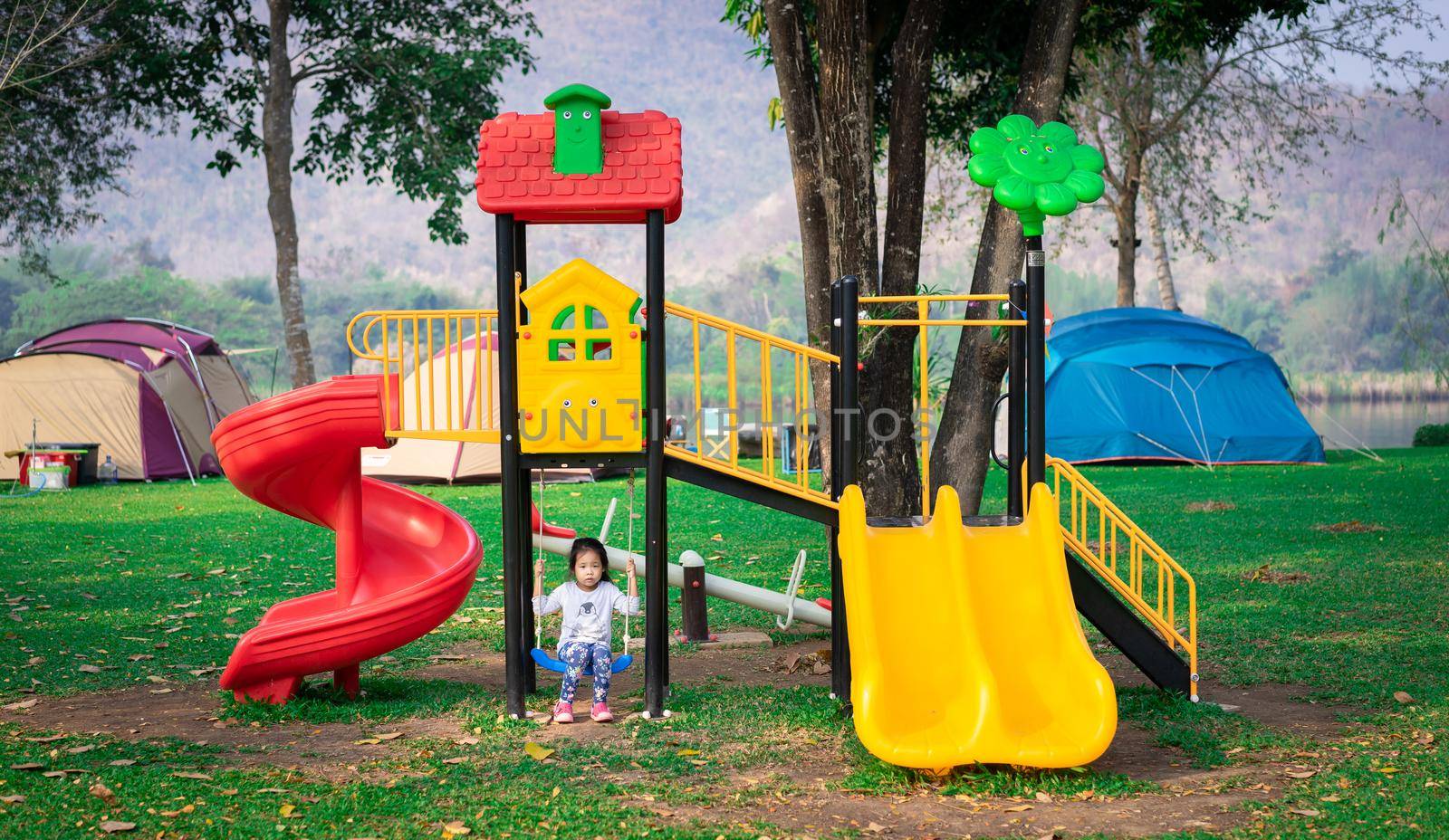 Asian little girl enjoys playing in a children playground