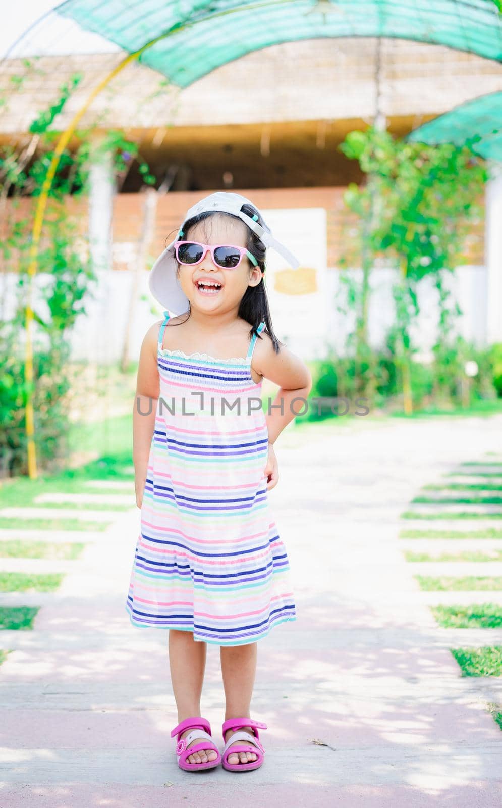 portrait of cute asian little girl wear sunglasses on footpath