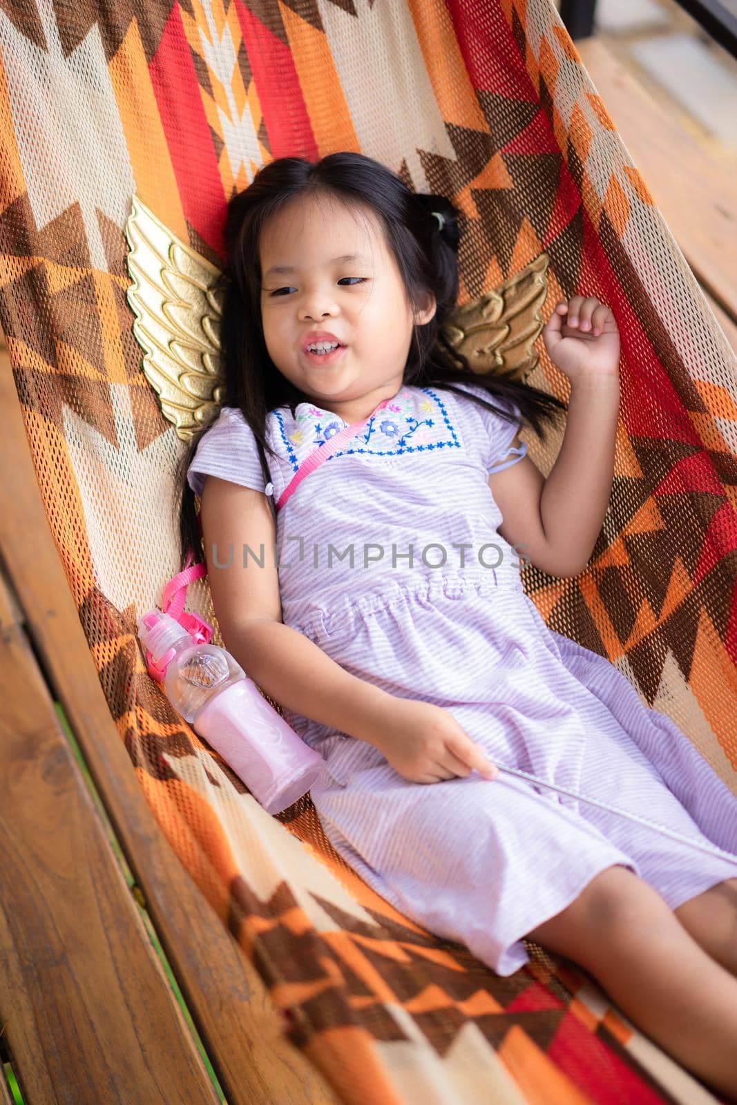 little asian girl in dress lying on cradle