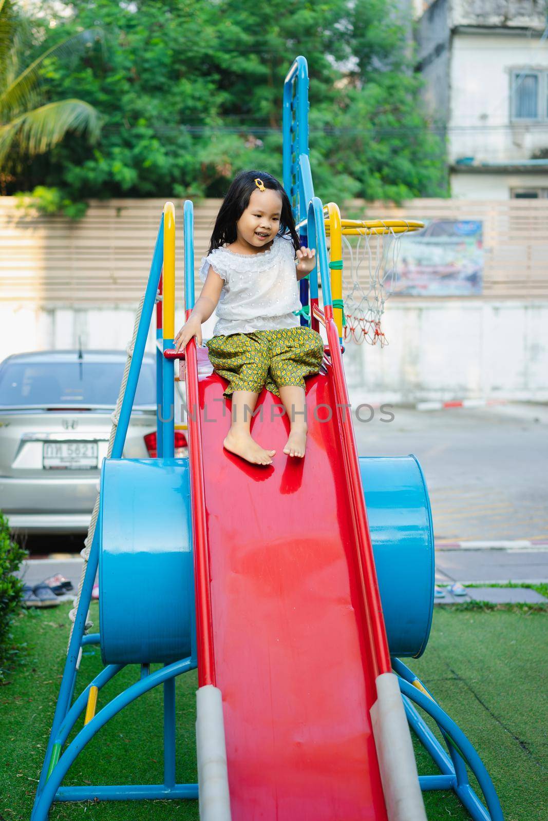 happy asian little girl in Thai period dress playing in a children playground