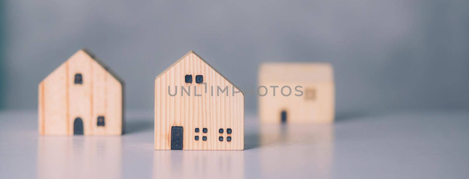 Mini wooden home model concept, investment of real estate and asset, tax of property and rental for finance, no people, small house and inspiration, mortgage and loan for residence, business concept. by nnudoo