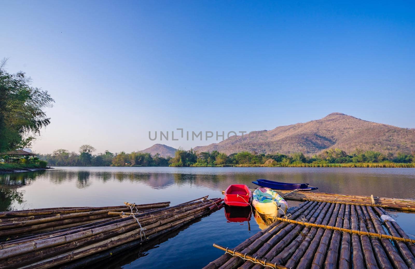 boats and raft on a mountain lake with sunlight.Natural dam lake in forest. by domonite