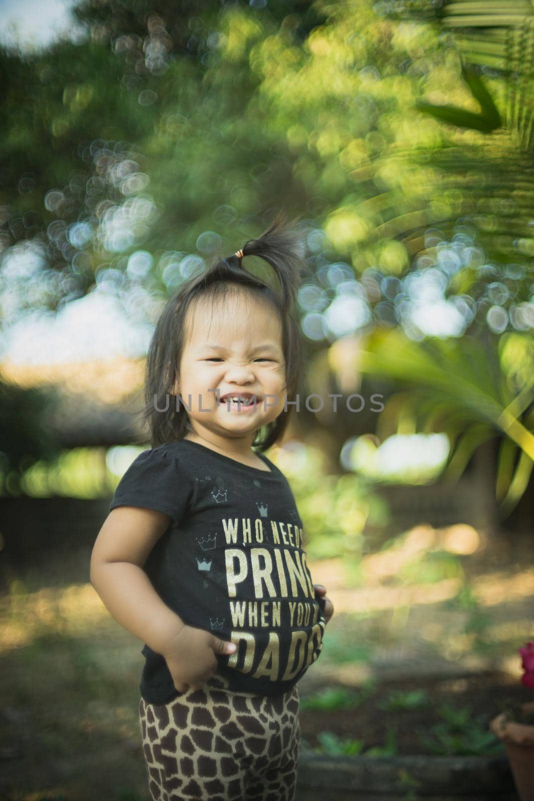 Little smiling child girl  standing with bokeh background