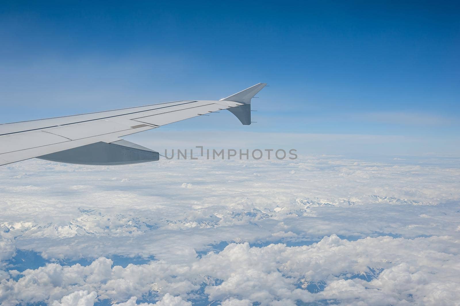 View from airborne airplane window at cloudy sky at high altitude. by Qba