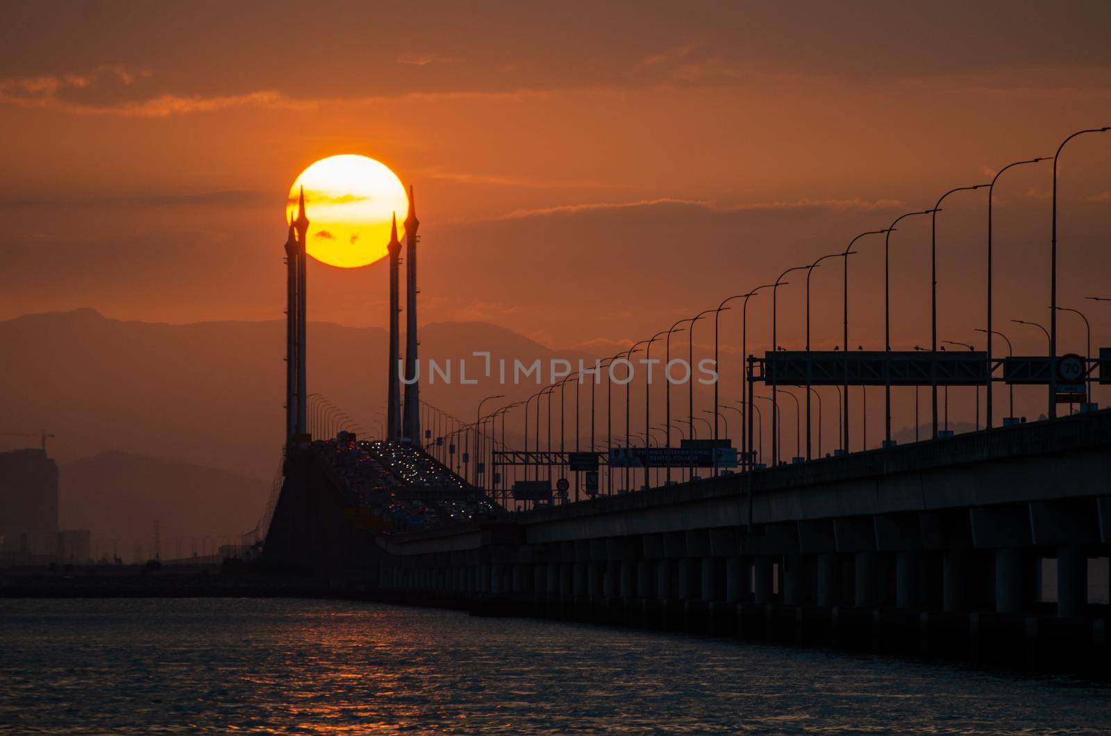 Georgetown, Penang/Malaysia - Feb 25 2020: Silhouette egg yolk sunrise at mid span of Penang Bridge.