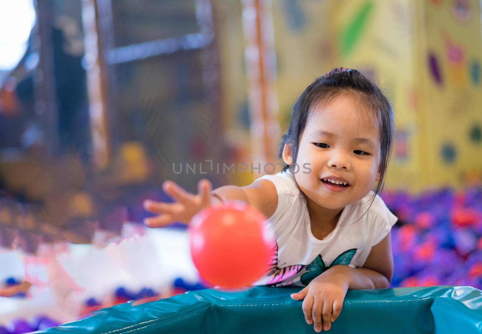 Asian little girl enjoys playing in a children playground by domonite